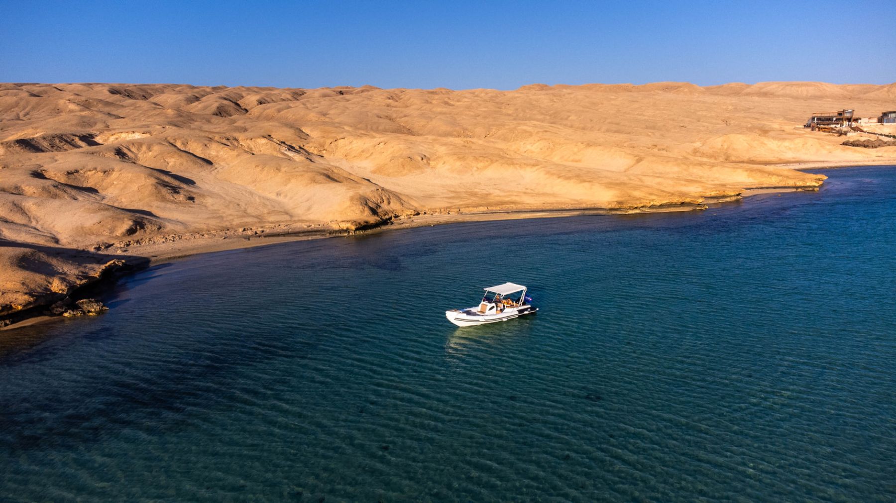 Maro Redsea speedboat anchored in a quiet turquoise bay along the Red Sea coastline near Hurghada