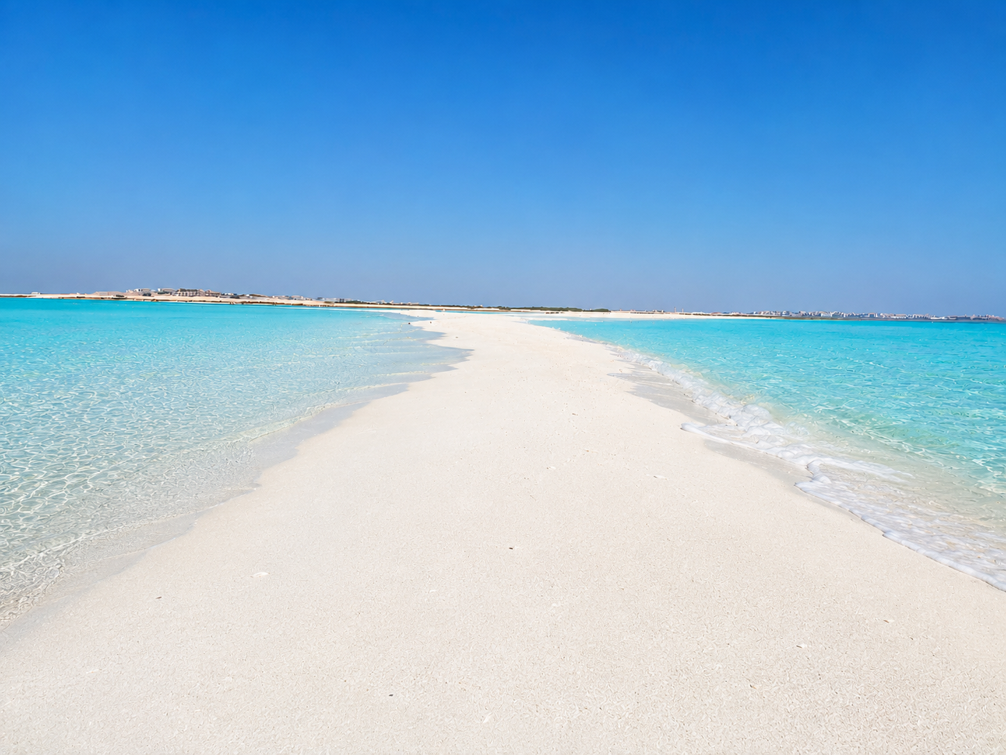Natural shallow sandbank stretching into clear turquoise Red Sea water